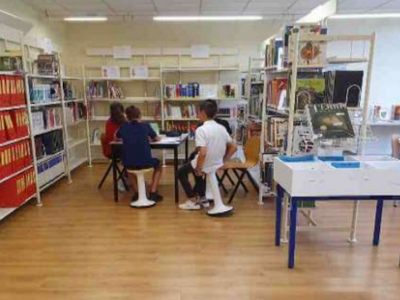 photo du CDI "après" composée d'élèves qui travaillent en groupe dans un espace bien délimité par des étagères de livres