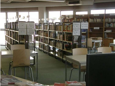 photo du CDI "avant" composée de tables et d'étagères de livres